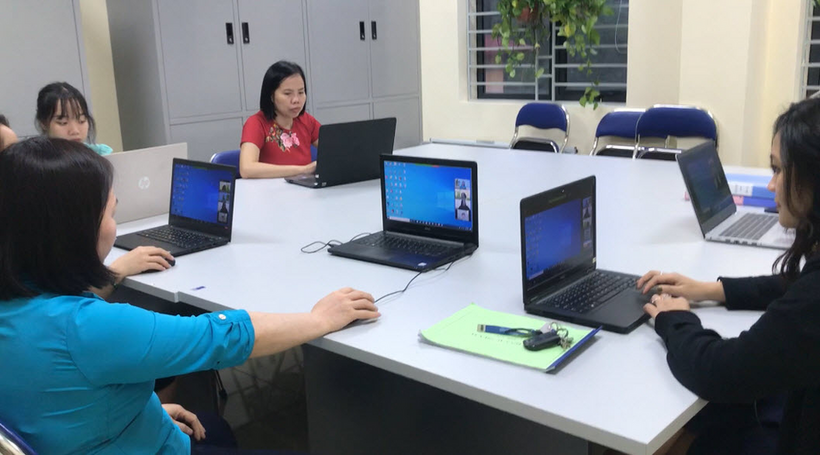 A group of people sitting at a table with laptops

Description automatically generated with medium confidence