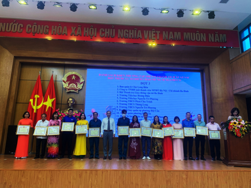 A group of people standing in front of a screen

Description automatically generated with medium confidence