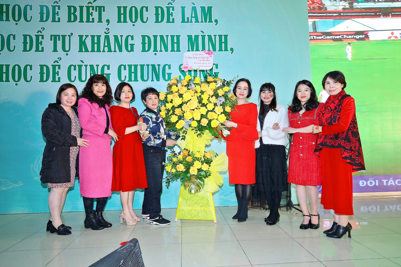 A group of women standing next to a bouquet of flowers
Description automatically generated with medium confidence