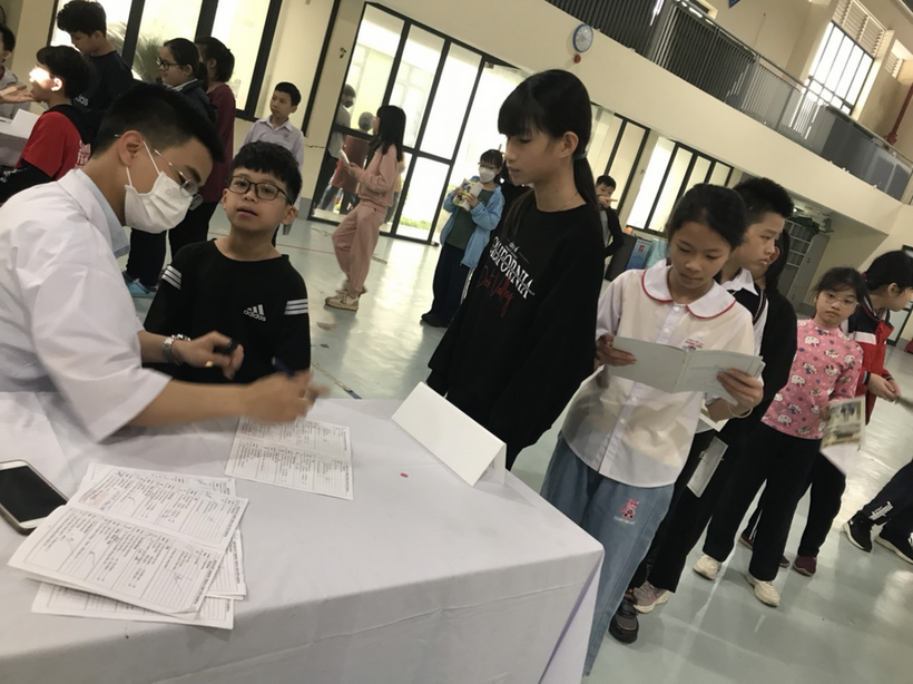A group of people standing around a table with papers on it

Description automatically generated with medium confidence