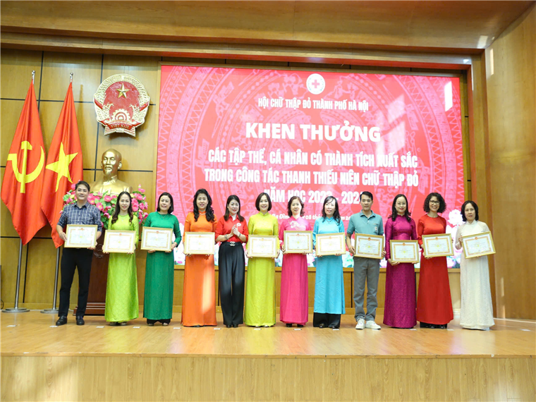 A group of people standing on a stage holding certificatesDescription automatically generated