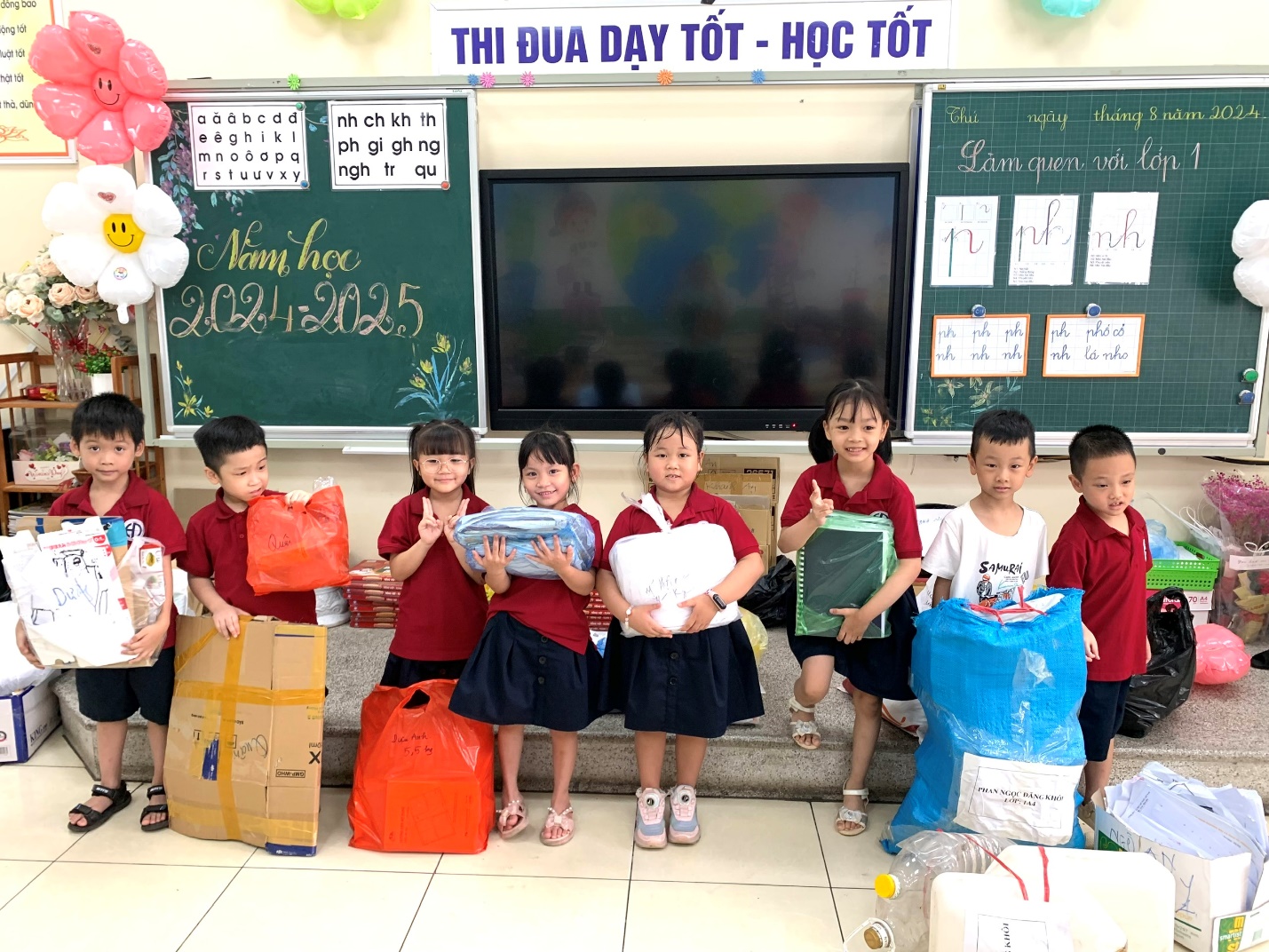 A group of children holding bags and booksDescription automatically generated