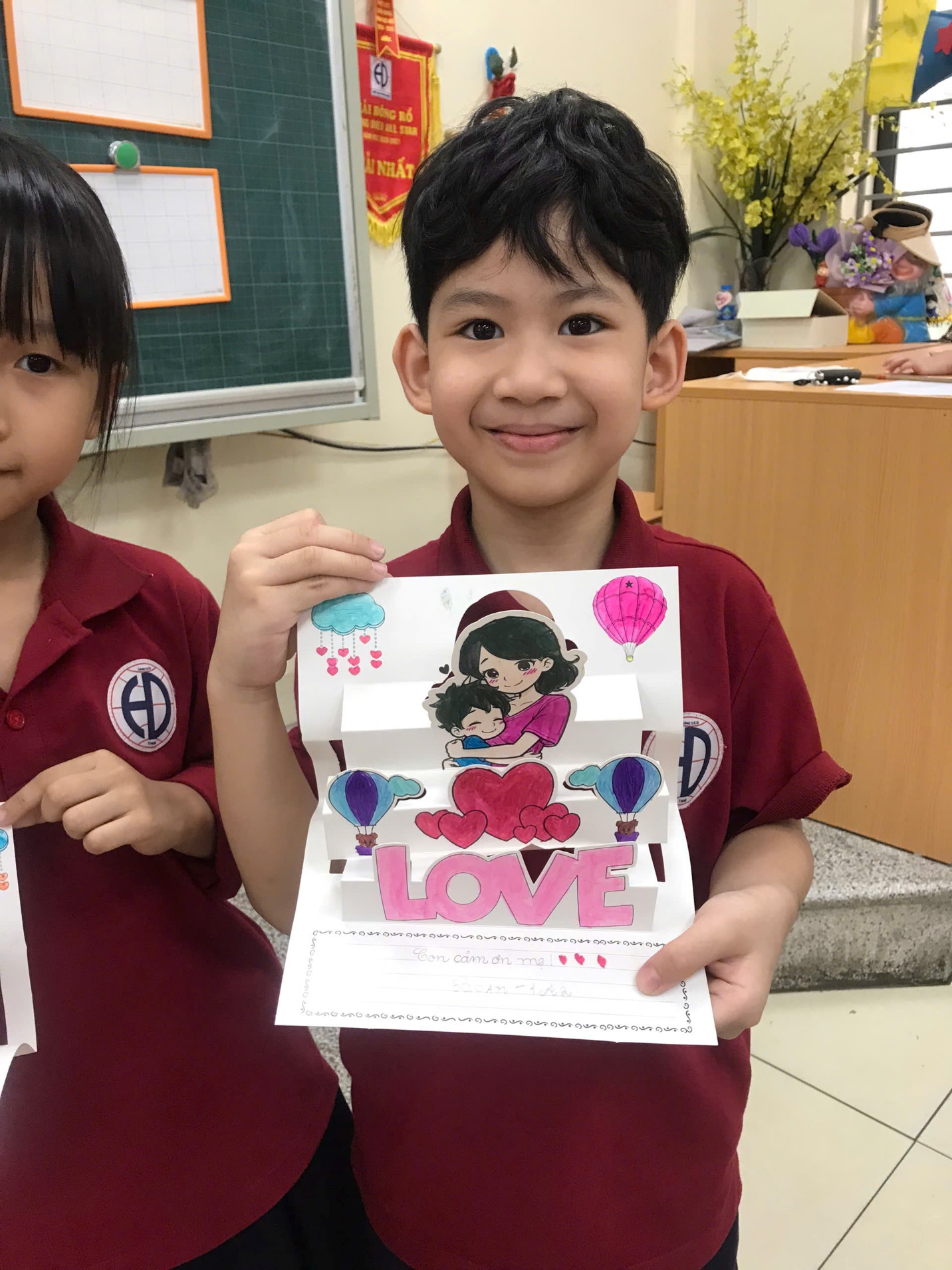 A child holding a cardDescription automatically generated
