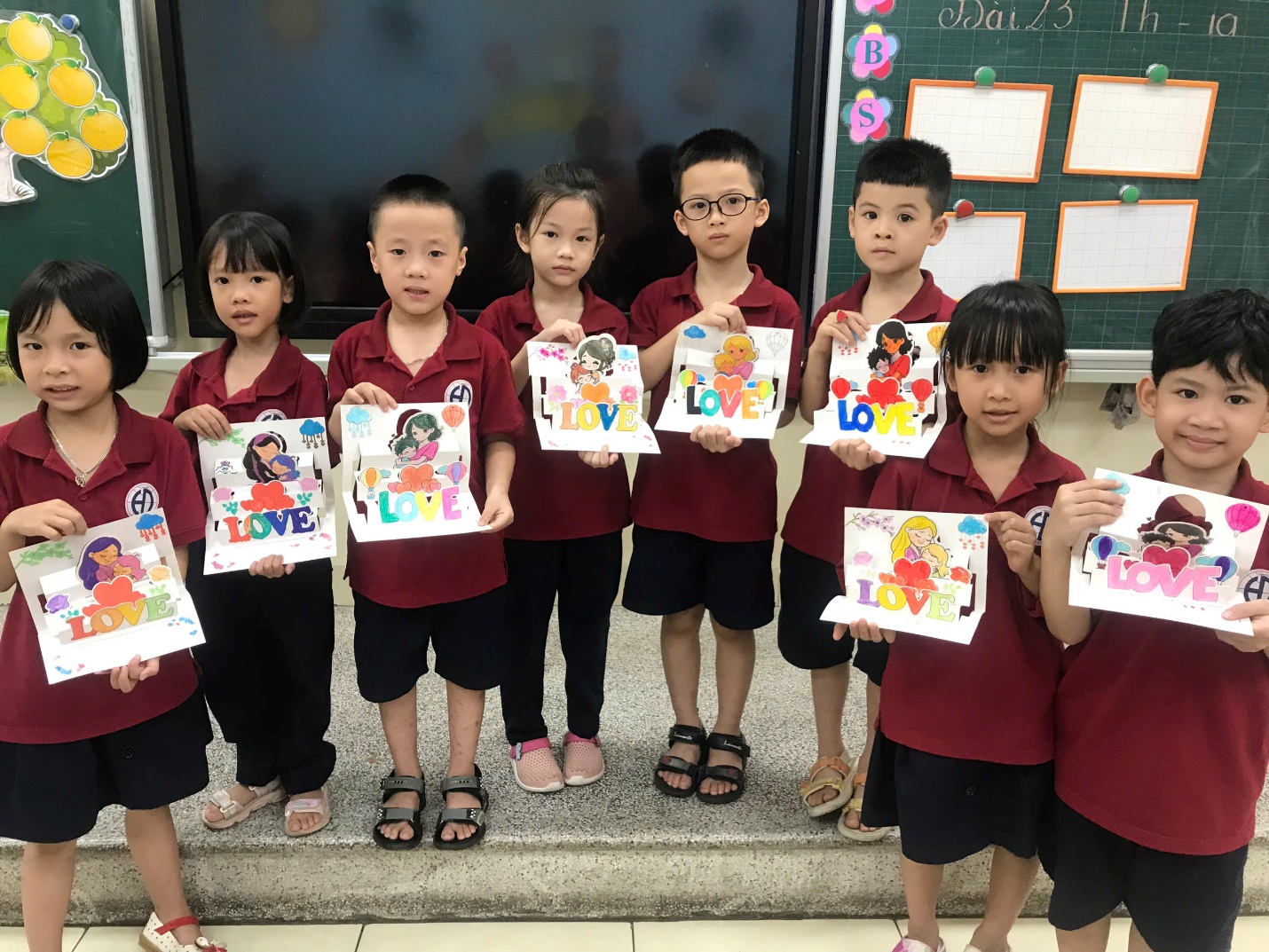 A group of children holding up a piece of paperDescription automatically generated