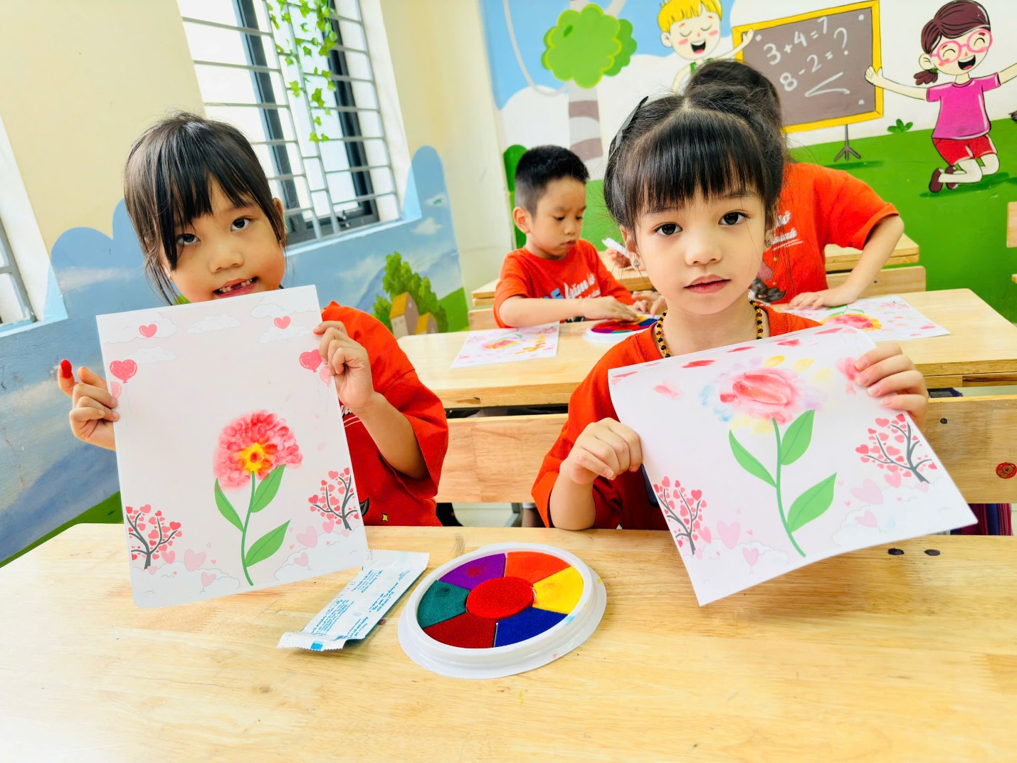 A group of children holding up picturesDescription automatically generated