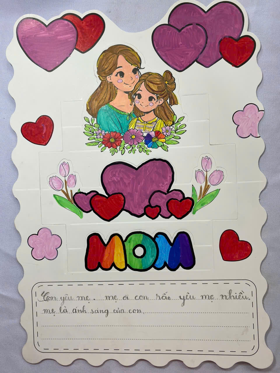A piece of paper with a drawing of a mother and her childDescription automatically generated