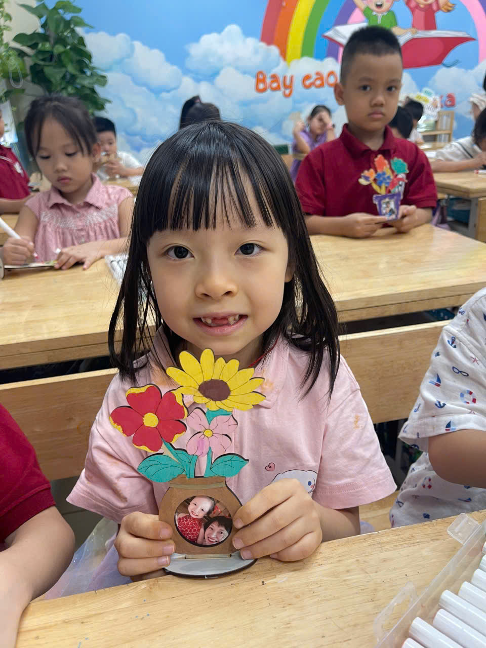 A child holding a paper flowerDescription automatically generated
