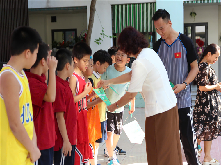 A group of people standing around a person holding a piece of paperDescription automatically generated
