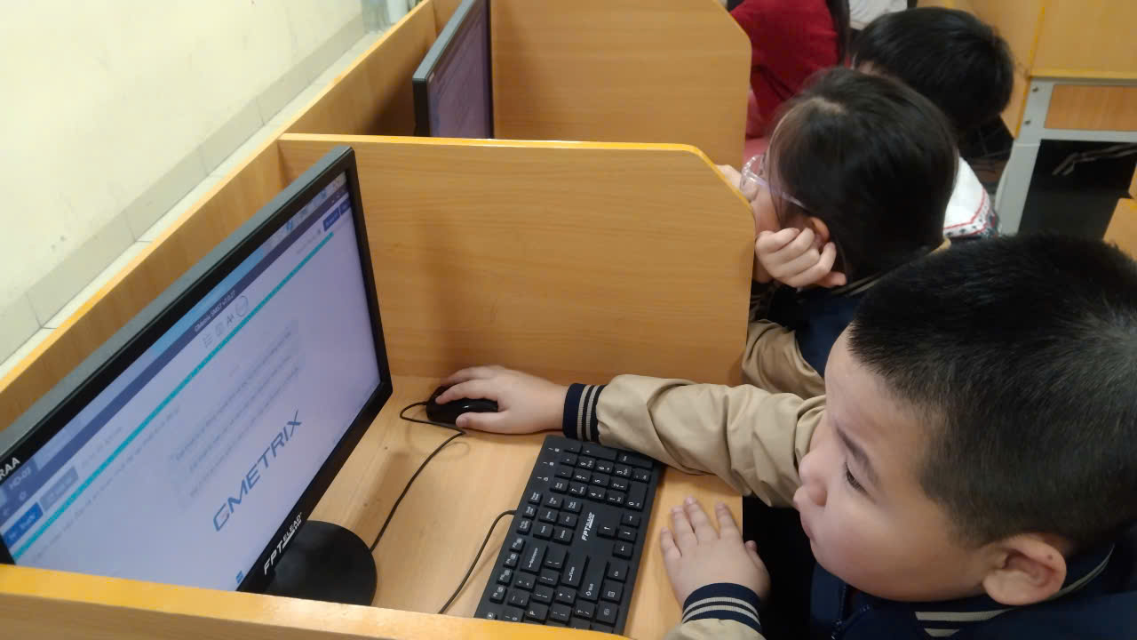 A group of kids using a computer

Description automatically generated