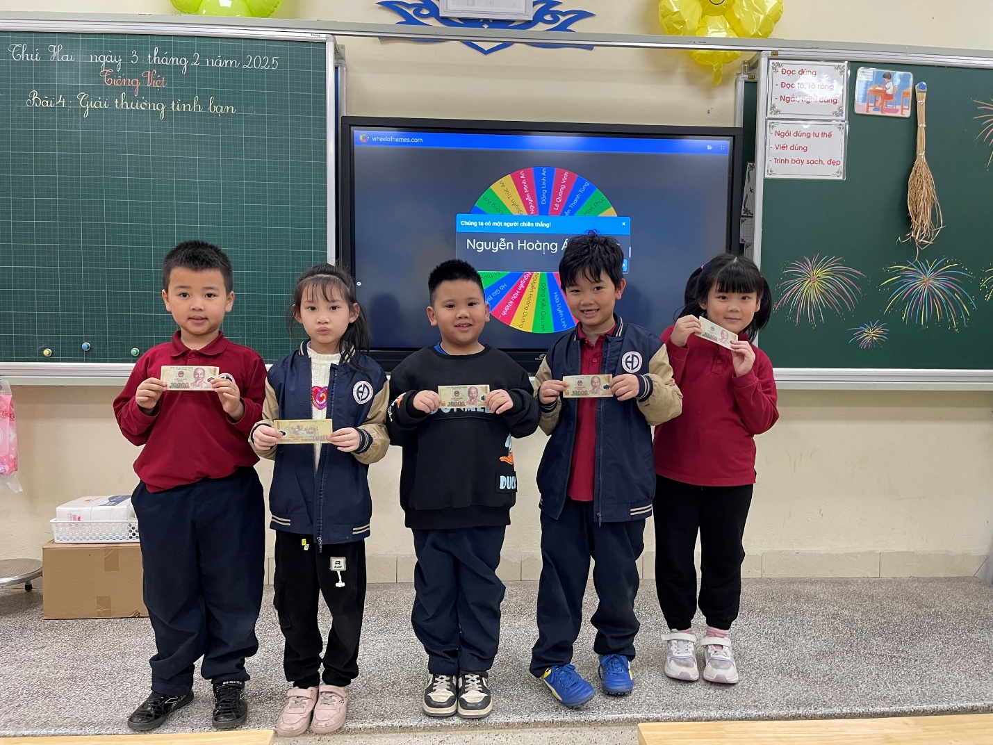 A group of children holding up signs in a classroomDescription automatically generated
