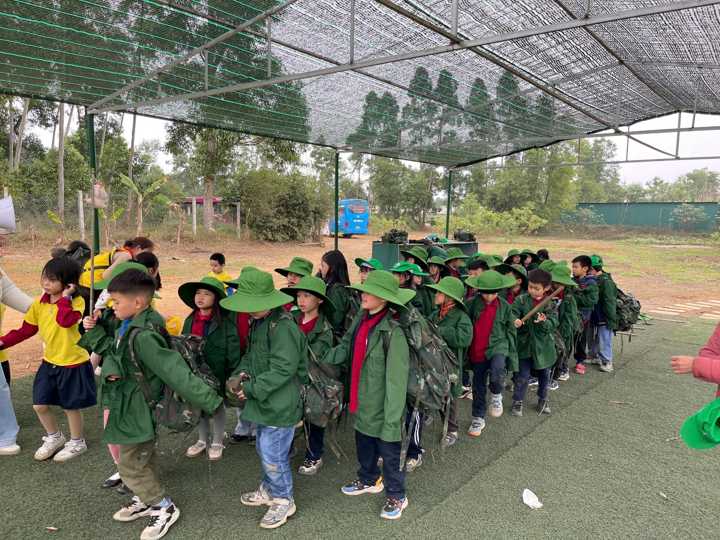 A group of children in green jacketsAI-generated content may be incorrect.