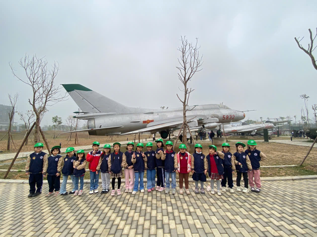 A group of children standing in front of a planeAI-generated content may be incorrect.