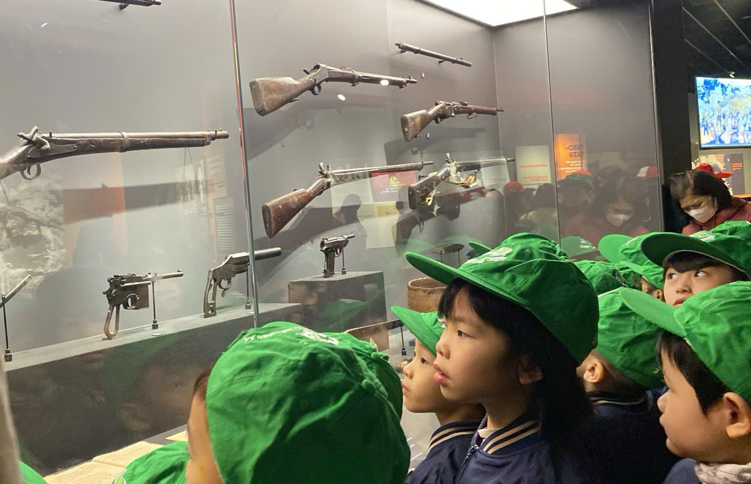 A group of children looking at gunsAI-generated content may be incorrect.