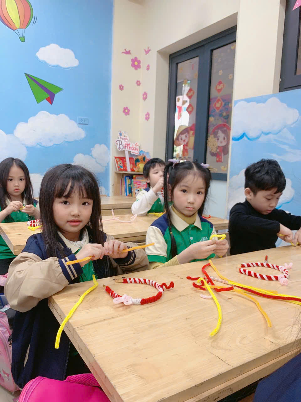 A group of children sitting at a tableAI-generated content may be incorrect.