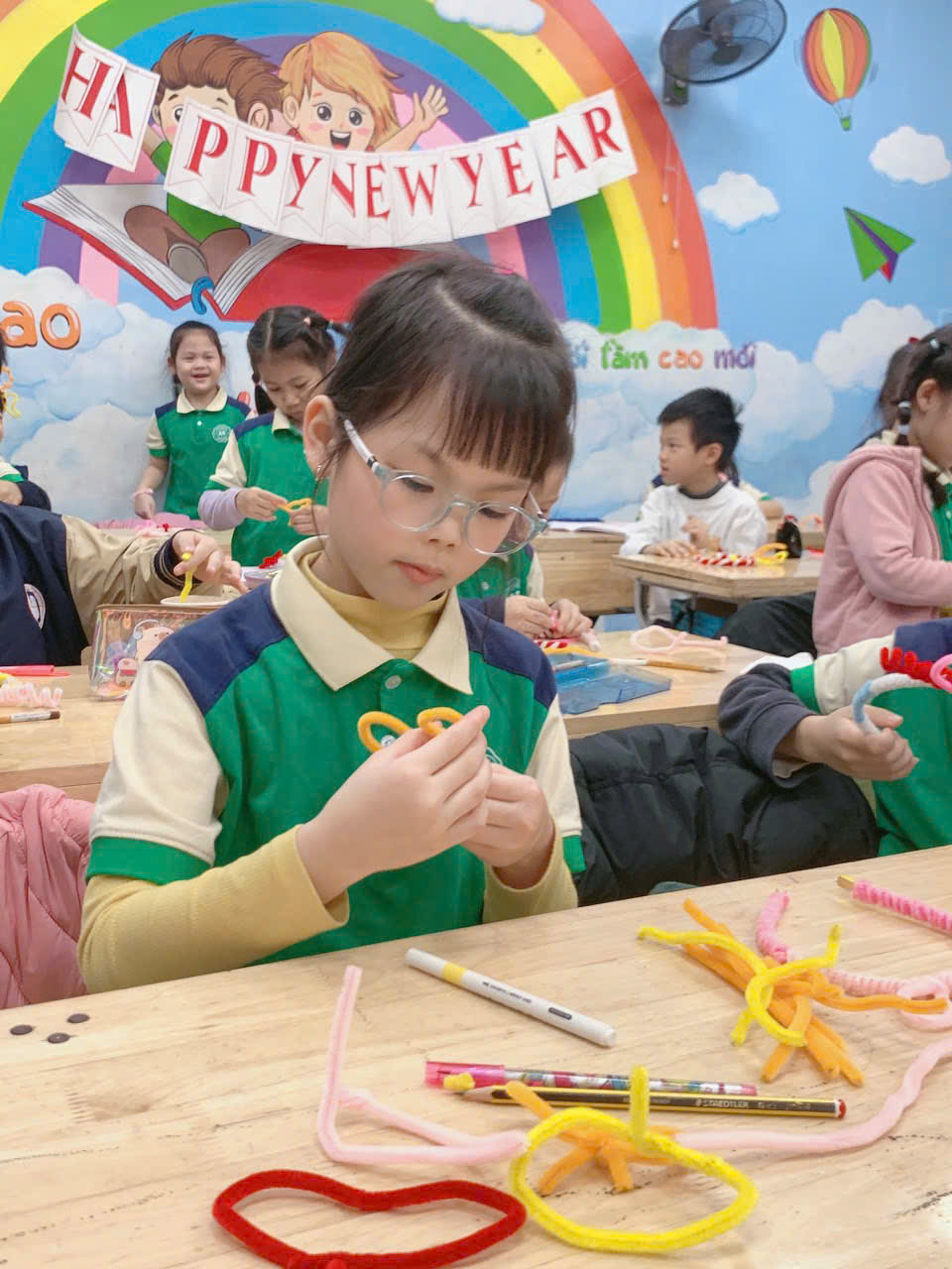 A young child sitting at a table with a few childrenAI-generated content may be incorrect.