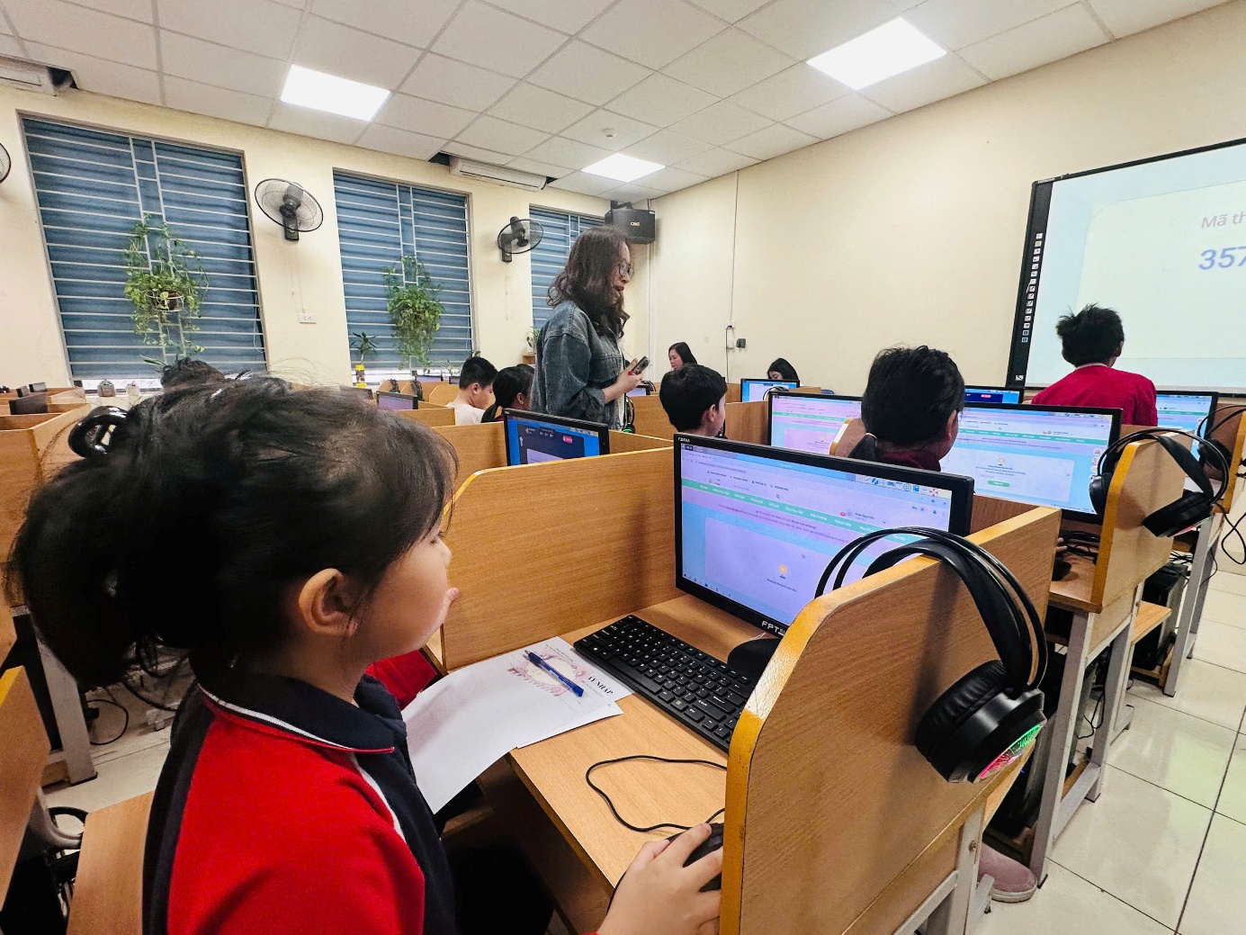 A group of children in a classroom using computersAI-generated content may be incorrect.