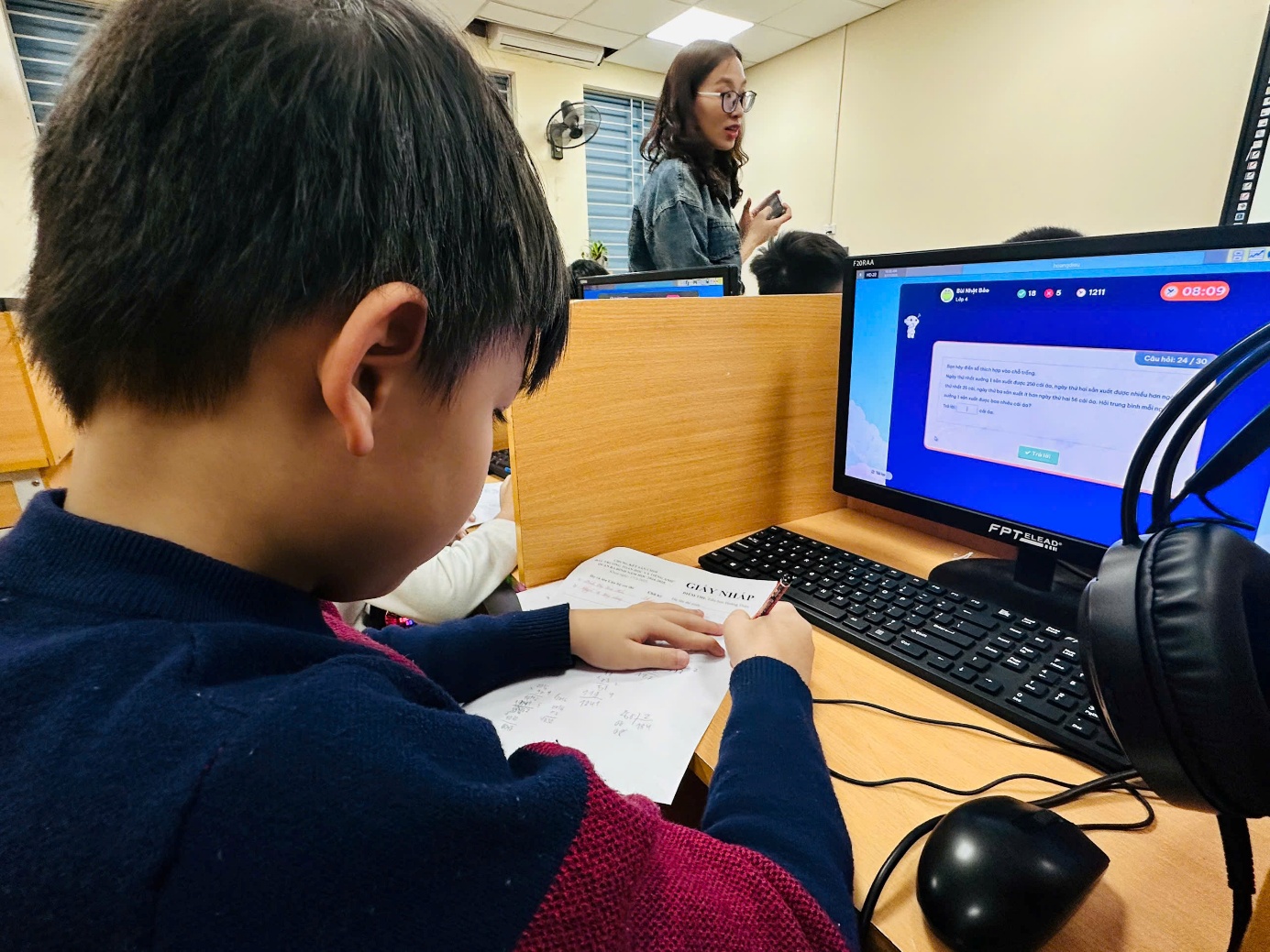 A child sitting at a desk with a computerAI-generated content may be incorrect.
