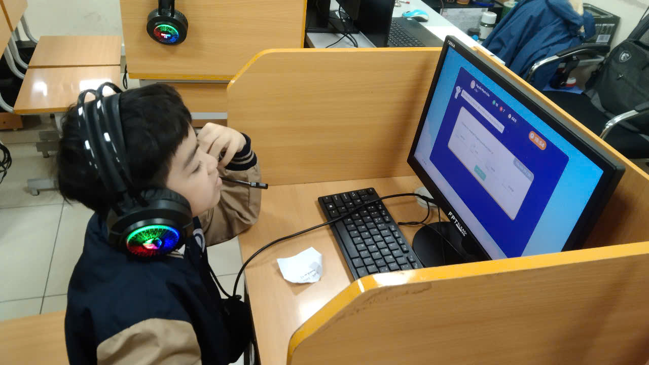 A child sitting at a desk with a computerAI-generated content may be incorrect.