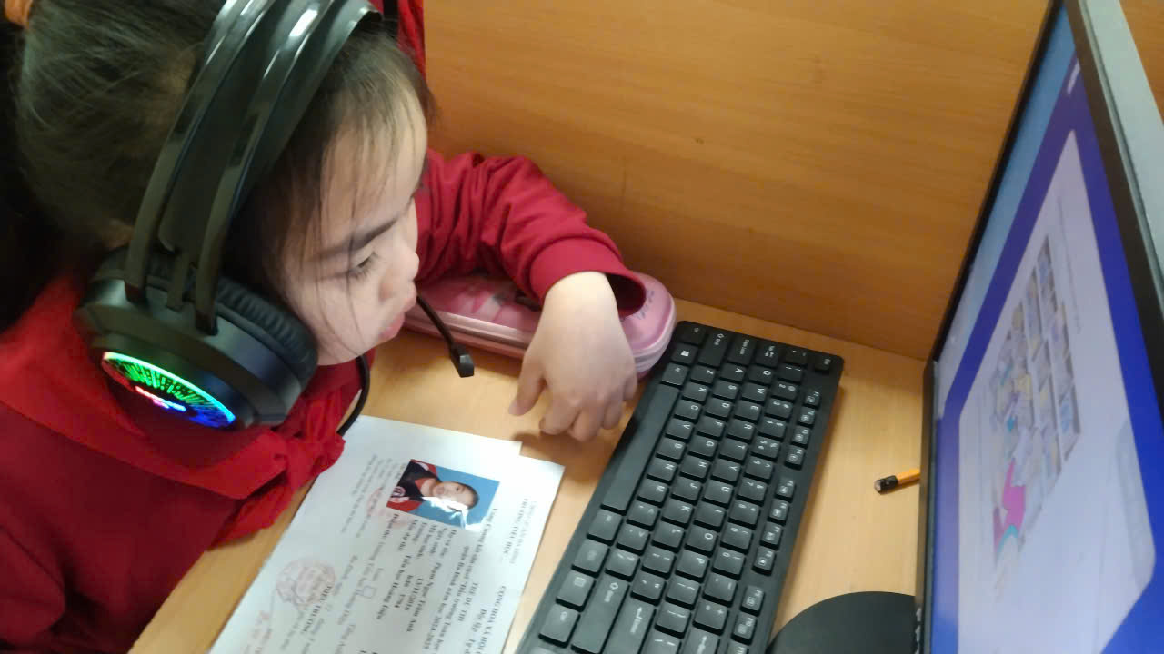A child wearing headphones looking at a keyboardAI-generated content may be incorrect.