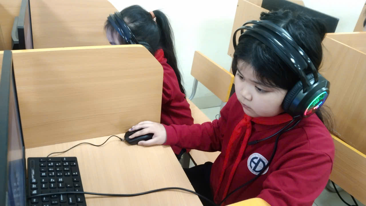 A child wearing headphones and using a computerAI-generated content may be incorrect.