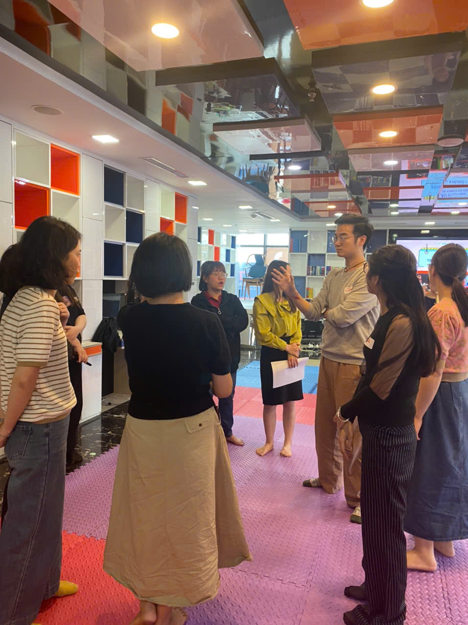 A group of people standing in a room

AI-generated content may be incorrect.