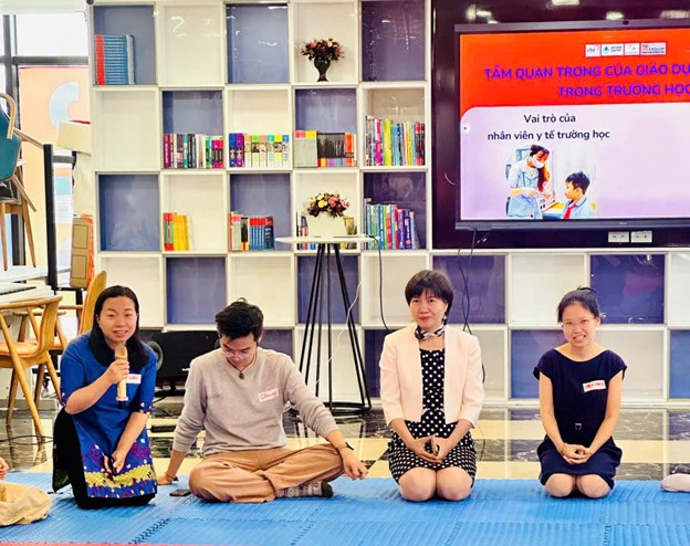 A group of people sitting on a blue mat

AI-generated content may be incorrect.
