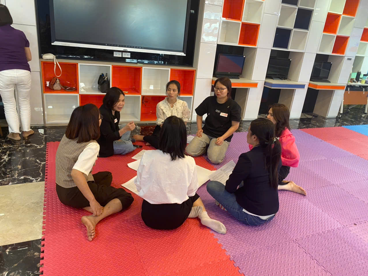 A group of people sitting on the floor

AI-generated content may be incorrect.