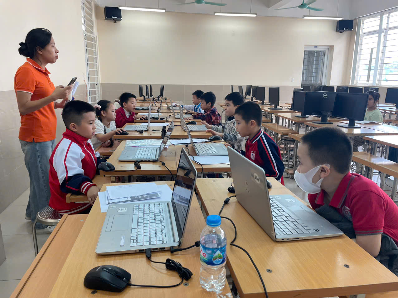 A group of children in a classroom with computersAI-generated content may be incorrect.