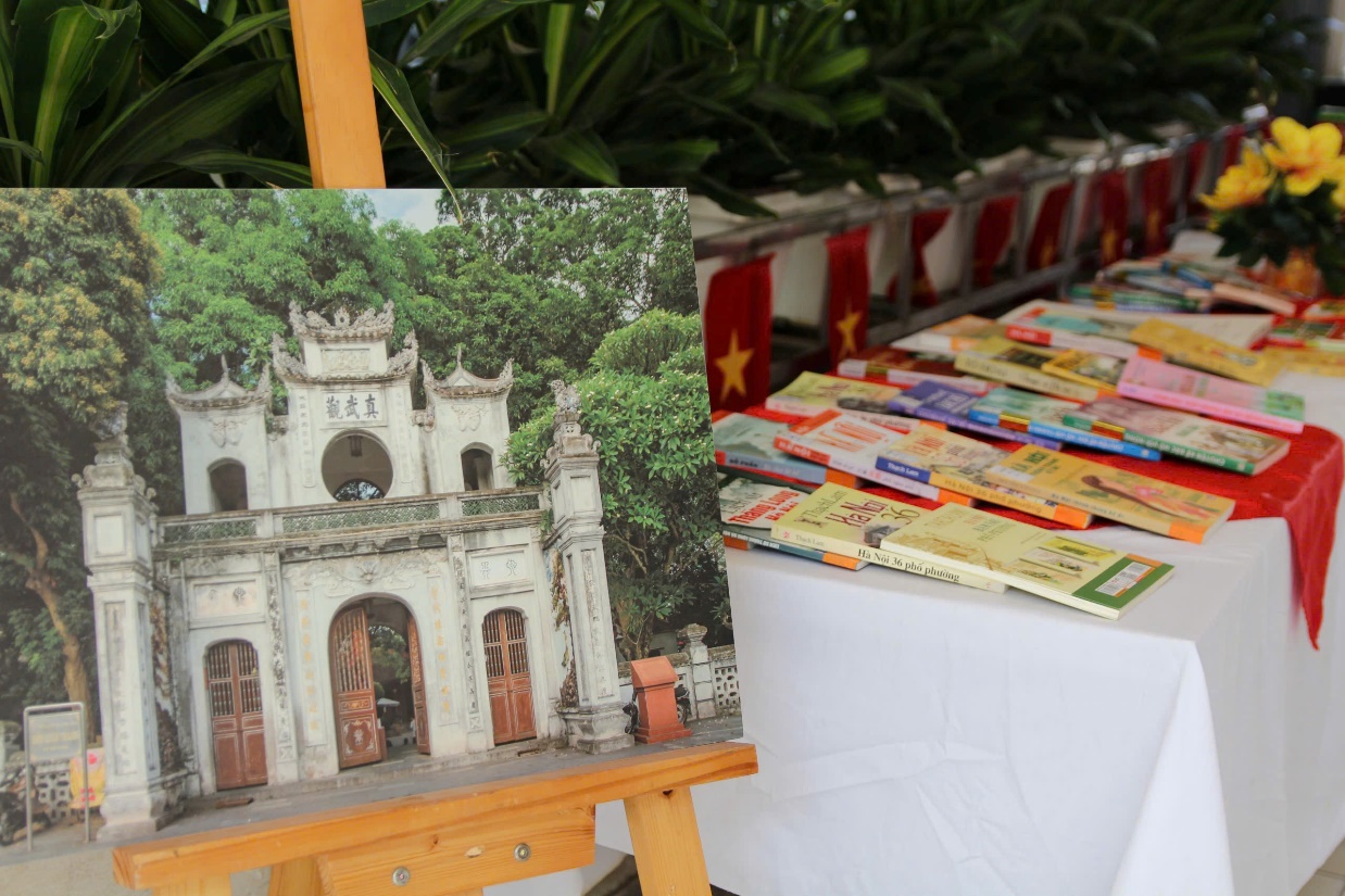 A table with a table with books and a picture of a building

AI-generated content may be incorrect.