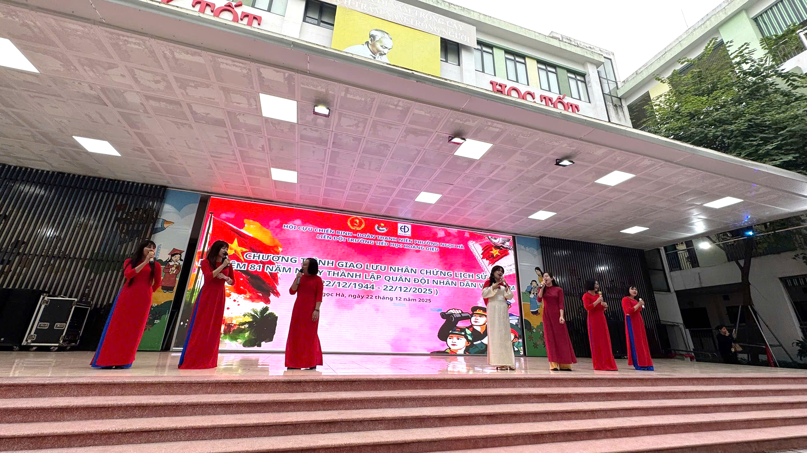 A group of women in red dresses performing on stairsAI-generated content may be incorrect.