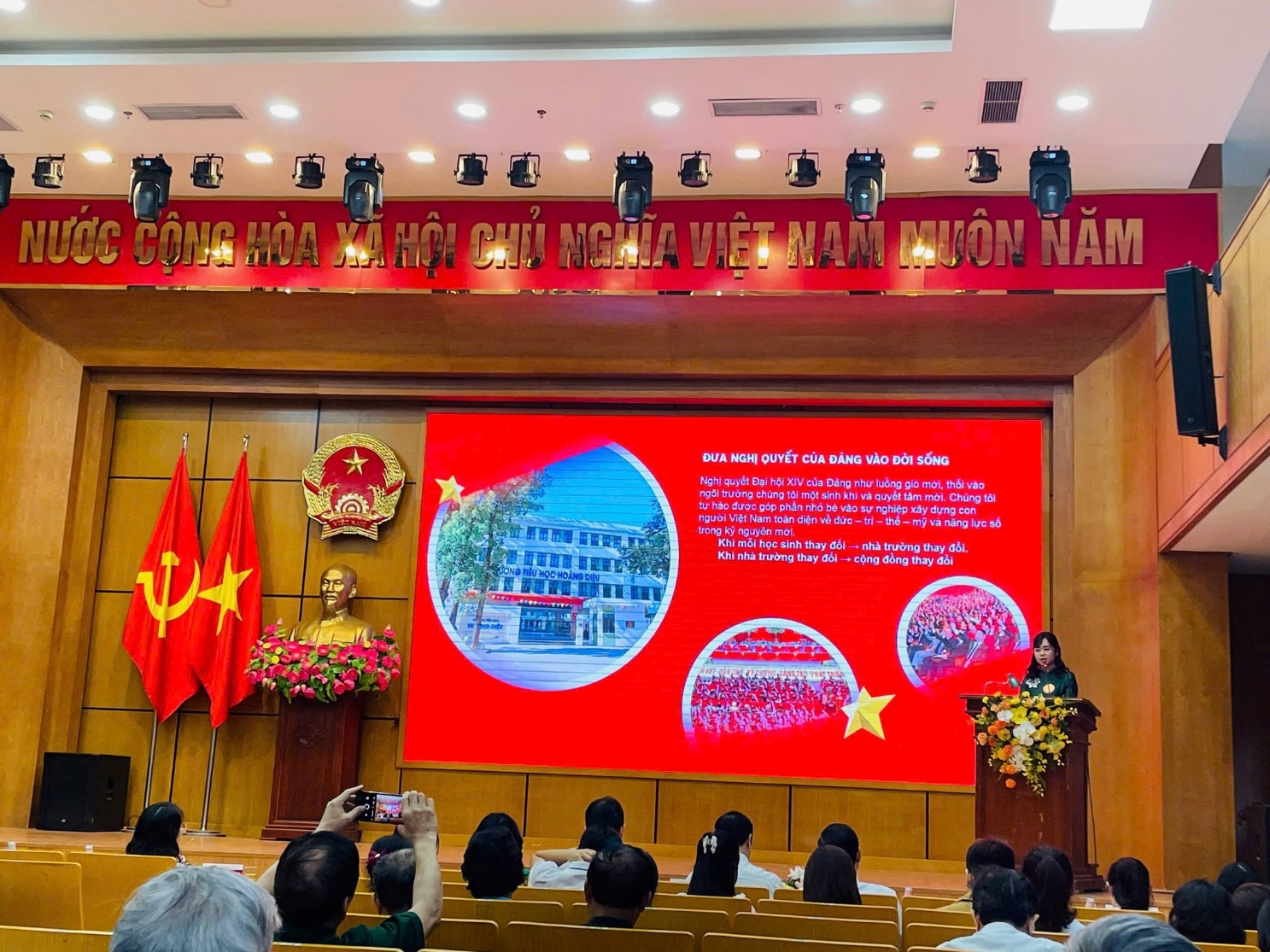 A group of people sitting in front of a stageAI-generated content may be incorrect.